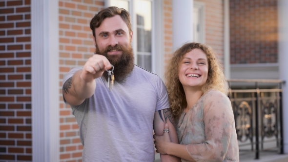 Family Couple Stand Near The House In Great Mood. alt