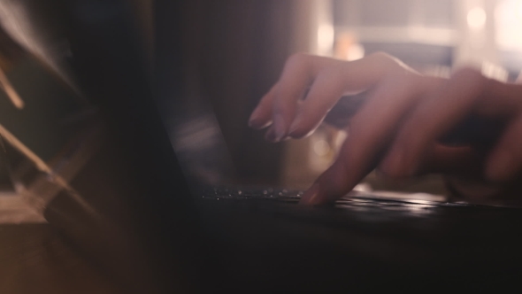 Woman Typing a Message On a Laptop At Night