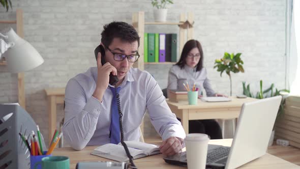 Sleepy Workers in the Officea Man and a Woman Sleeping at Work Answering the Phone alt