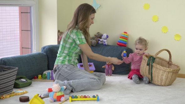 Happy Mother Woman With Adorable Toddler Daughter Girl Put Toys In Basket