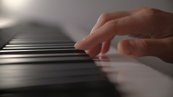 Woman's Hand Playing The Piano
