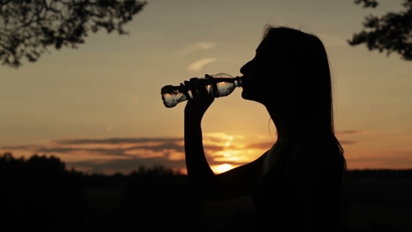 Silhouette Of Young Woman Drinking Water