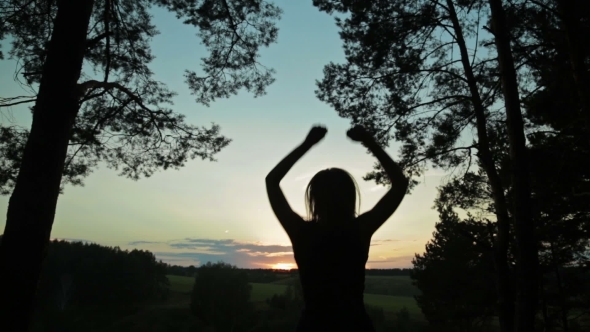 Young Woman Jumping And Dancing In The Forest After Sunset
