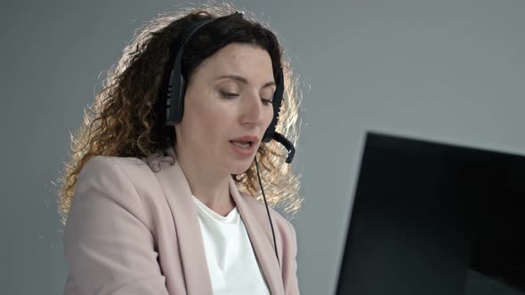 Customer Support Agent or Call Center with Headset Works on Desktop Computer While Supporting the alt