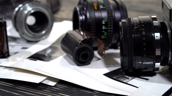 Vintage 35mm Cameras, Lenses, Photos And Film Are Piled Up.