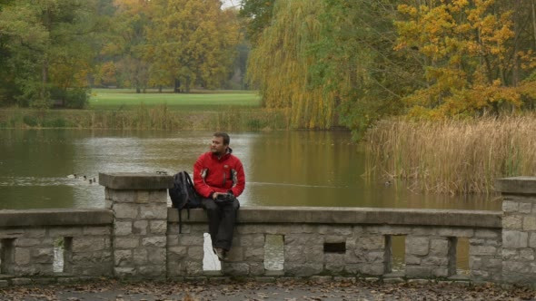 Tourist Takes Off 360Vr Glasses Sitting On Bridge alt