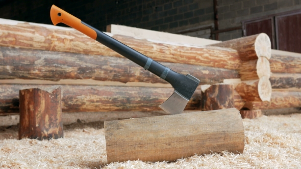 Modern Black Axe Lies In a Large Pile Of Sawdust.  Of The Cutting Part Of The Axe