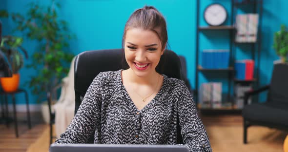 Young Pretty Brunette Girl Video Chatting with Friends While Sitting at a Desk in a alt