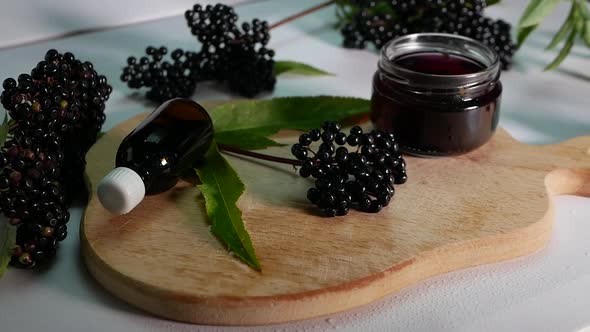 Black Elderberry Herbal Medicine, Ripe Elderberry On A White Background. In Slow Motion Camera