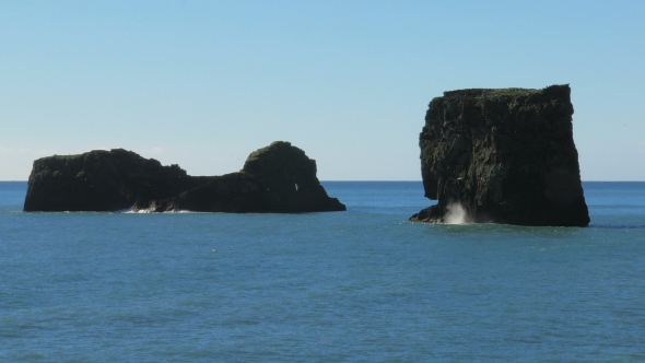 Basalt Rocks On a Middle Of Ocean, In Sunny Day, Flocks Of Birds Flying Around
