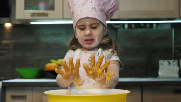 Girl with messy hands playing in the kitchen alt