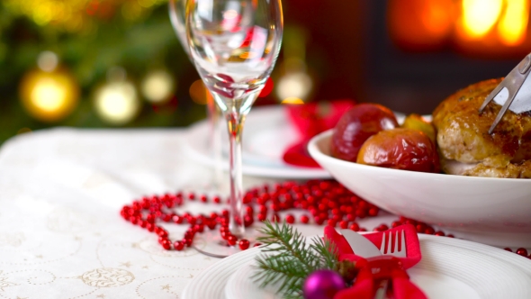 Roasted Chicken On Christmas Table In Front Of Fireplace And Tree With Lights