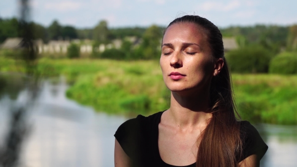 Portrait Of a Young Woman Who Meditates On a Background Of Nature With Eyes Closed