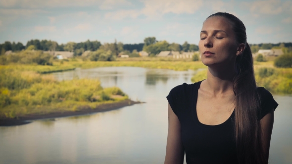 Portrait Of a Young Woman Who Meditates On a Background Of Nature With Eyes Closed