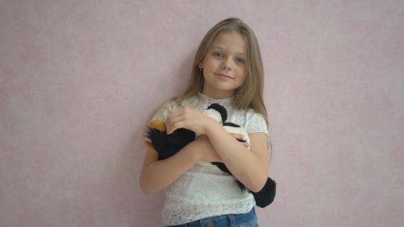 Pretty Little Girl Holding a Soft Toy And Smiling At Camera alt