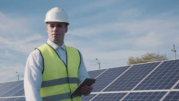 Technician Walks Beside Array Of Solar Panels alt