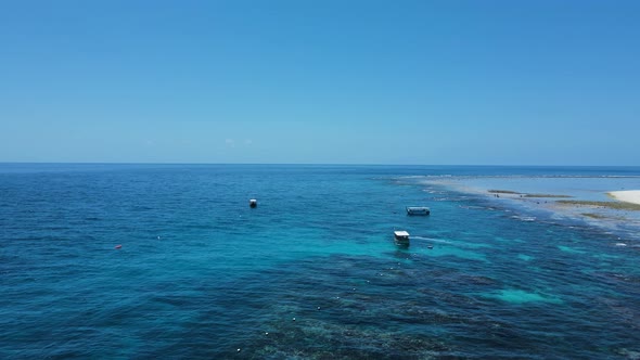 Scuba diving boats floating above a tropical reef in the blue waters of a tropical Island. Drone vie alt