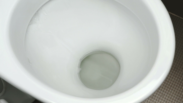 The Process Draining Of Water Into a White Toilet