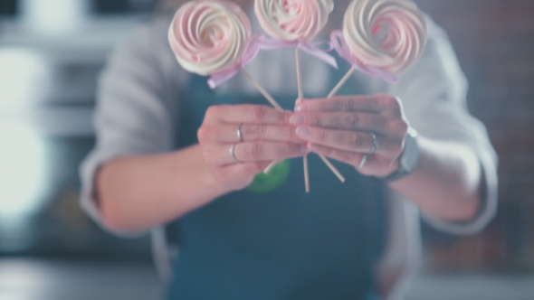 Treats On a Stick In The Hands Of Women. Woman Holding Three Treats.