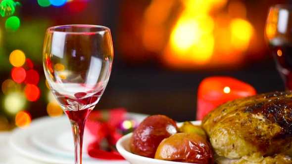 Wine Pouring To Glass On Christmas Table In Front Of Fireplace