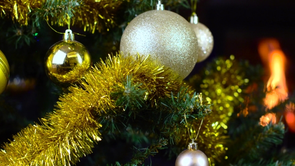 Decorated Christmas Tree With Lights In Front Of Fireplace