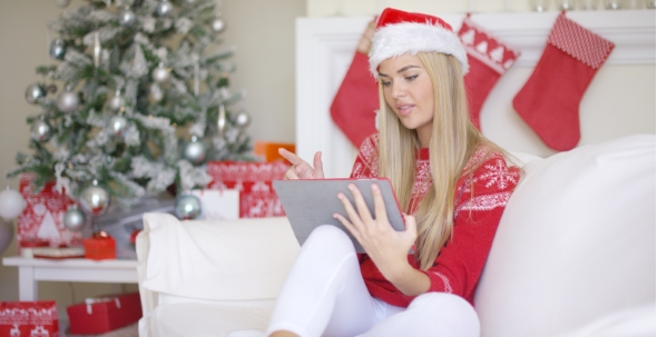 Pretty Blond Young Woman Sitting On Couch With Touchpad alt