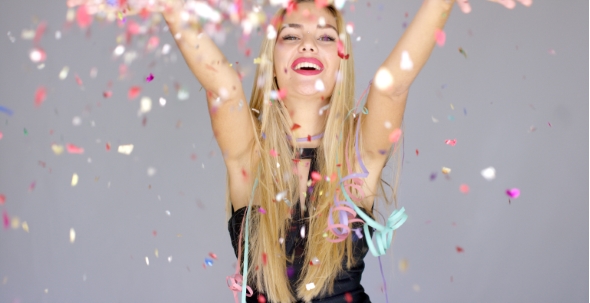 Sexy, Blond Girl Blowing Confetti To Camera Direction alt