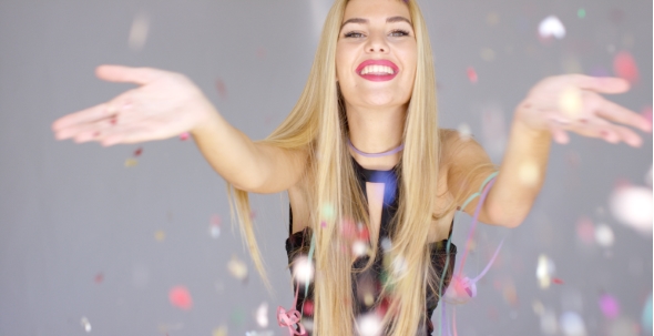 Sexy, Blond Girl Blowing Confetti To Camera Direction alt
