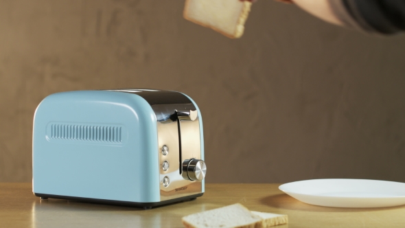 Man Puts Two Loaves Of Bread Into An Electric Toaster