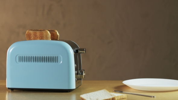 Man Puts Two Loaves Of Bread Into An Electric Toaster alt