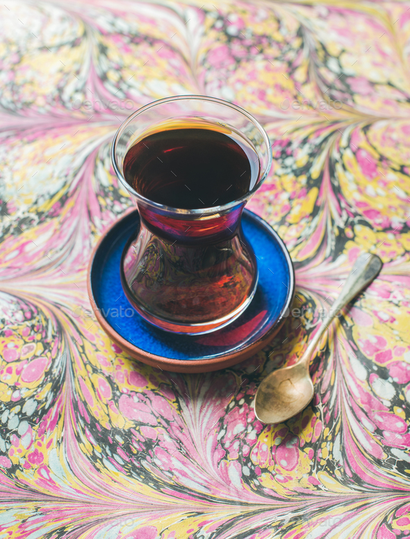 Turkish tea in traditional oriental tulip glass over colorful background