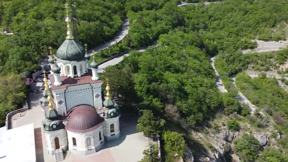 Aerial View of Foros Church and Mount Road Through the Spring Forest alt