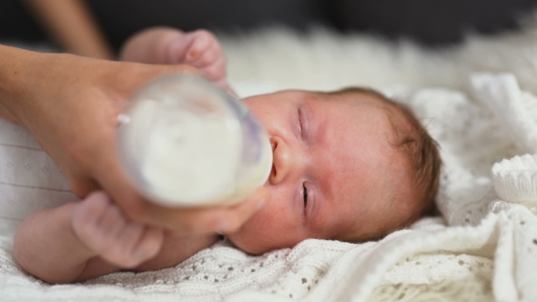 Baby Drinking Milk From Feeding Bottle