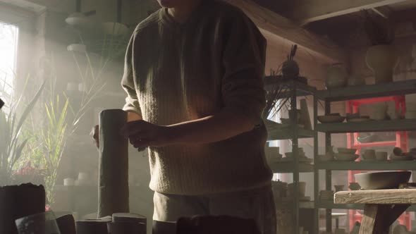 Woman Is Cutting Clay With String Tool alt