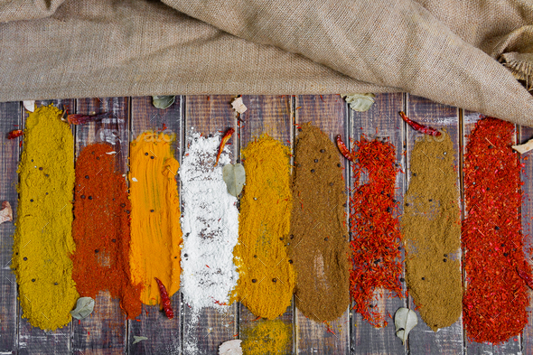 Colourful spices on the table. Various Spices in on wooden background, top view. Spices background