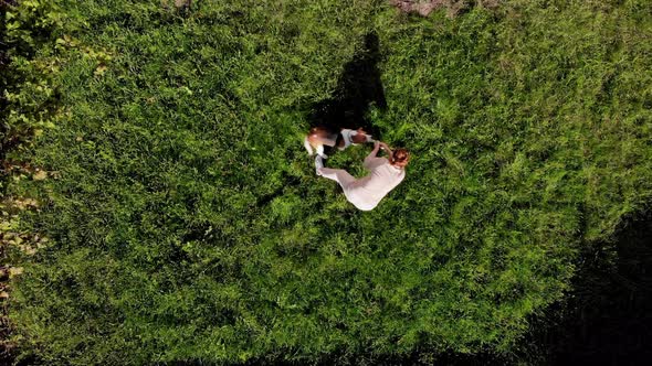 Top View Girl Playing with Dog Beagle at Grass Outdoors in a Green Park and Teases His Puppy with alt