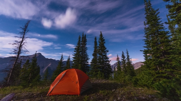 Clouds And Stars At Night Passing Over a Tent In The Mountains