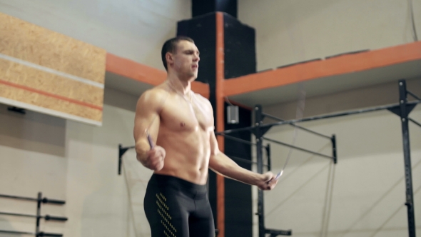 Fit Young Man Doing Jump Rope Exercises At Gym alt