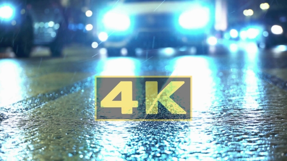 Pedestrians And Falling Snow On Wet Crosswalk In Winter. Snowflakes In Headlight