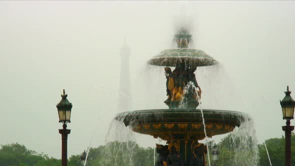 Shot of a fountain with a silhouetted Eiffel Tower in the background. alt