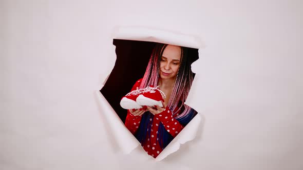 Young Woman in Red Dress with Shoes in Hole of White Background in Studio alt