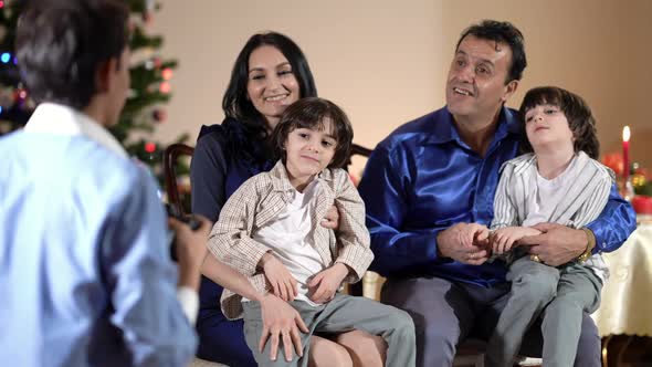 Caucasian Mother and Middle Eastern Father with Twin Sons in Living Room on Christmas As Teenage Boy alt