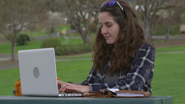 Woman at park on working on laptop computer