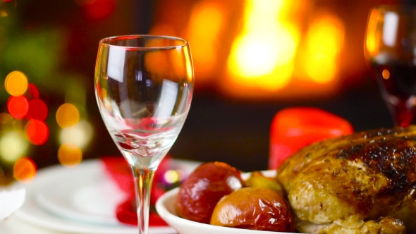 Wine Pouring To Glass On Christmas Table In Front Of Fireplace