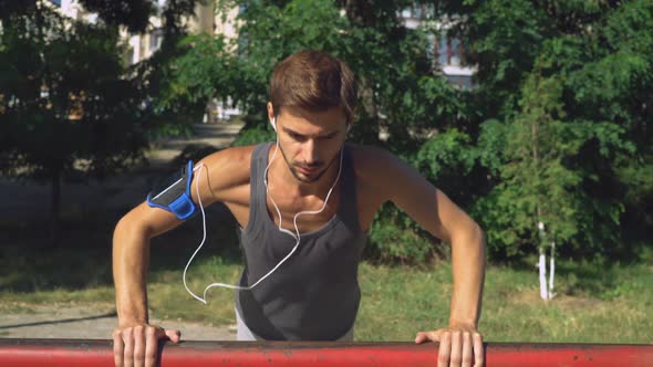 Young Sports Guy Squeezed From Tubes in a Park Outdoors alt