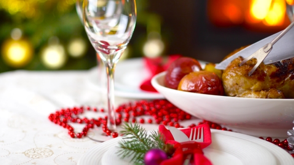 Roasted Chicken On Christmas Table In Front Of Fireplace And Tree With Lights