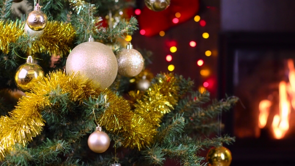 Decorated Christmas Tree With Lights In Front Of Fireplace