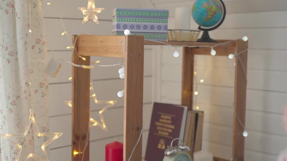 Man Hanging Santa Hat on the Shelf alt