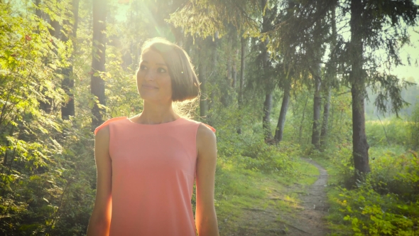 Walking Girl In a Pink Dress In The Woods On a Sunny Day.