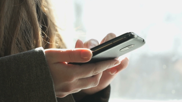 Girl Looking For Information Using The Smartphone